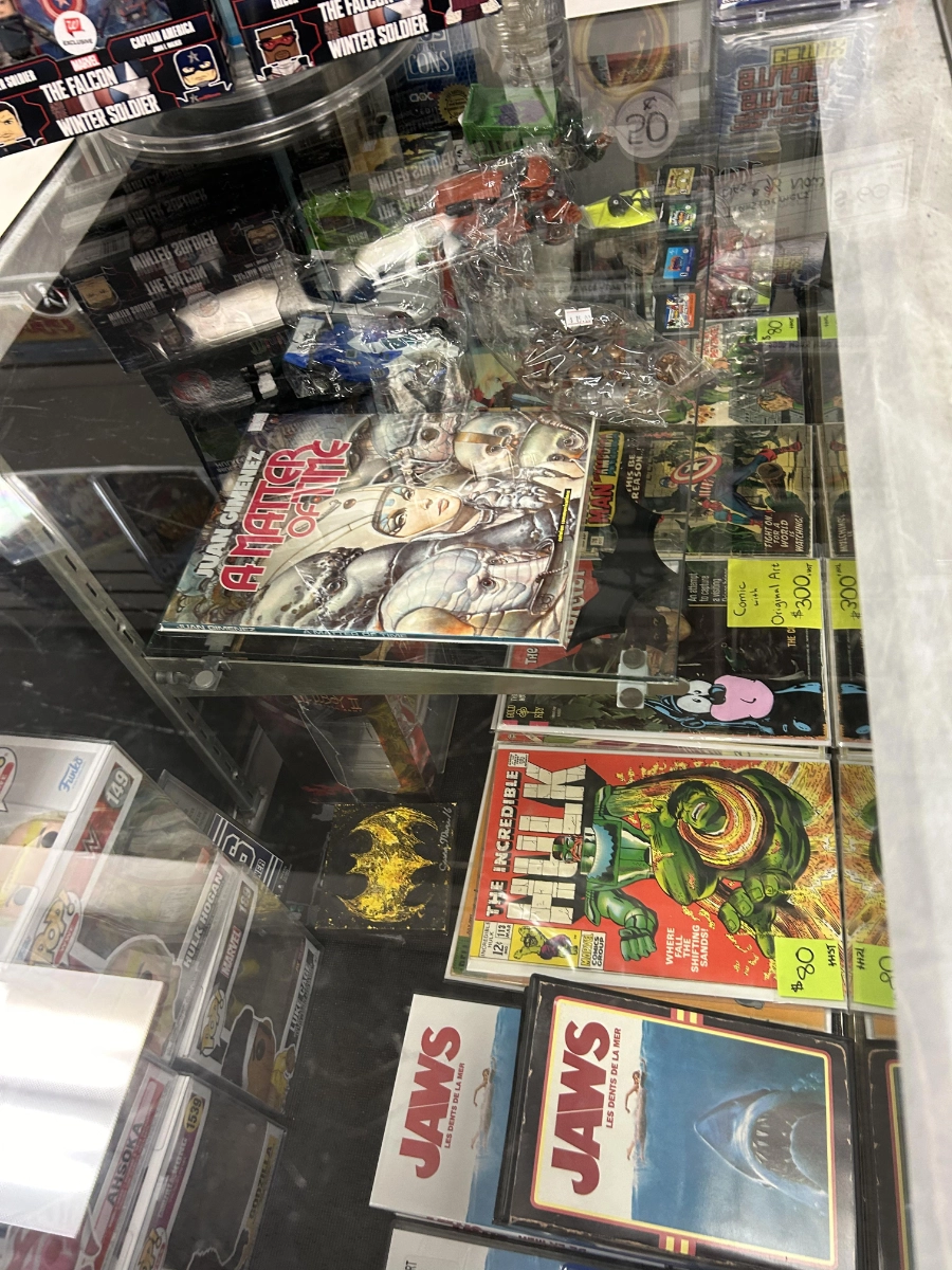 A glass showcase of collectibles and graded comics